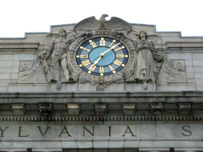 A clock on top of a building that says ‘ylvania’