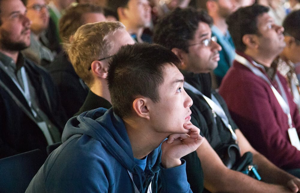 A group of researchers engaged at a conference talk.